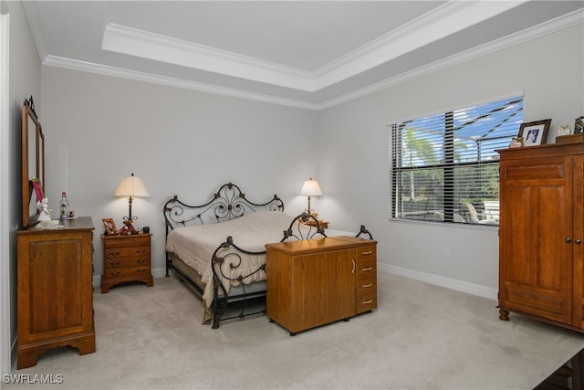 carpeted bedroom with crown molding and a tray ceiling