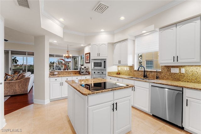 kitchen featuring sink, white cabinets, a kitchen island, and appliances with stainless steel finishes