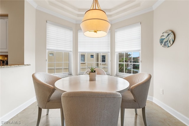 dining space with light tile patterned flooring, ornamental molding, and a tray ceiling