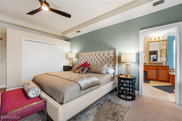 carpeted bedroom with connected bathroom, ceiling fan, a closet, and ornamental molding