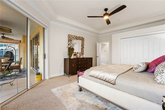 carpeted bedroom with ceiling fan, access to exterior, ornamental molding, and a tray ceiling