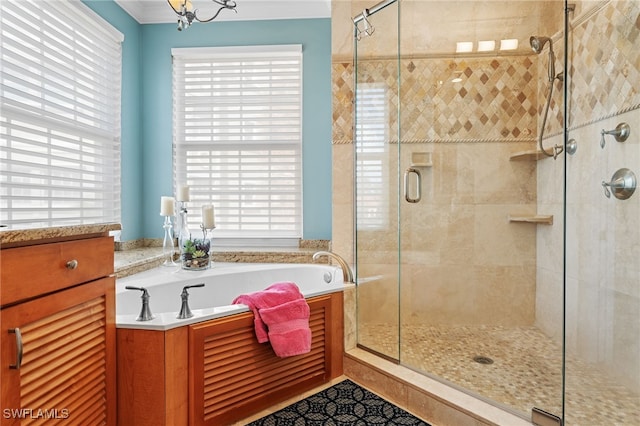 bathroom with separate shower and tub, a wealth of natural light, and an inviting chandelier