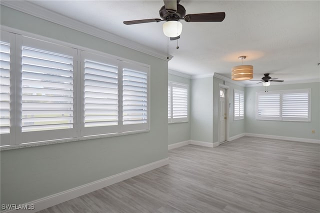 empty room with ceiling fan, light hardwood / wood-style flooring, and ornamental molding