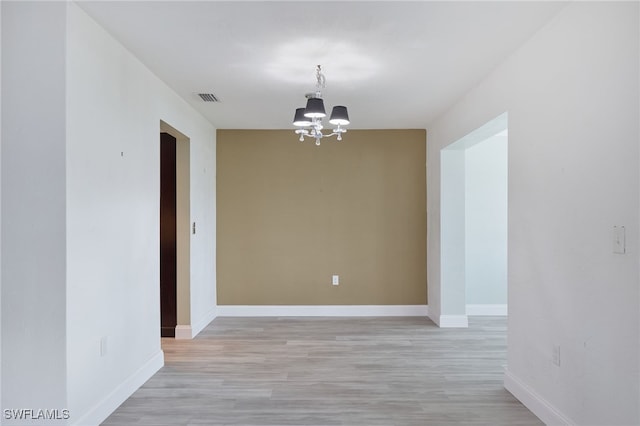 unfurnished dining area featuring light hardwood / wood-style flooring and a chandelier