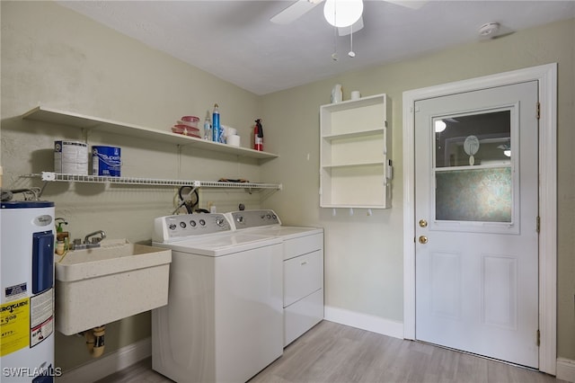 clothes washing area featuring ceiling fan, sink, washing machine and dryer, water heater, and light wood-type flooring