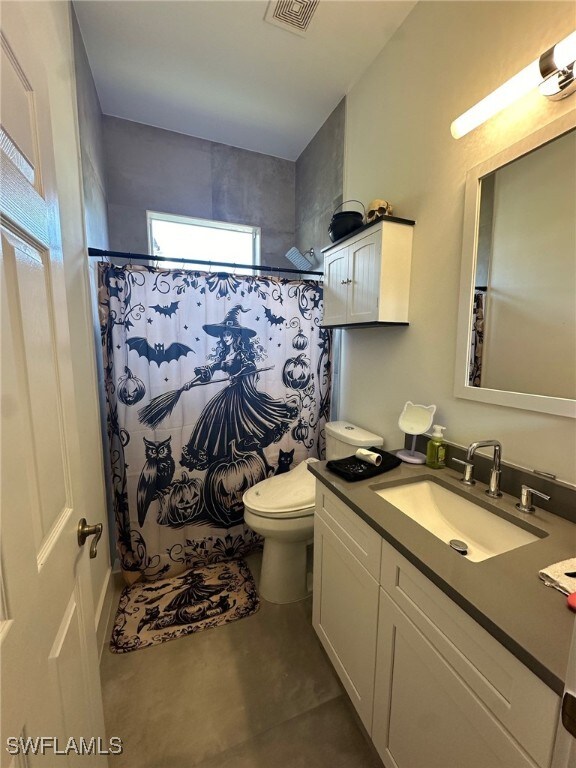 bathroom featuring a shower with curtain, vanity, and toilet