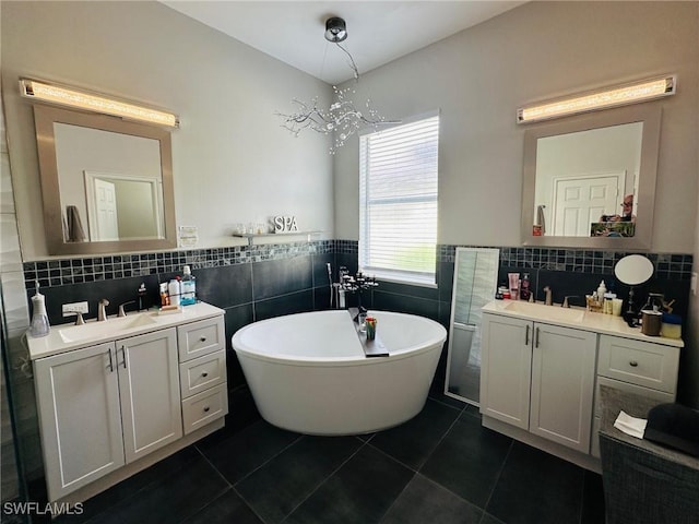 bathroom with tile patterned flooring, vanity, and a tub to relax in