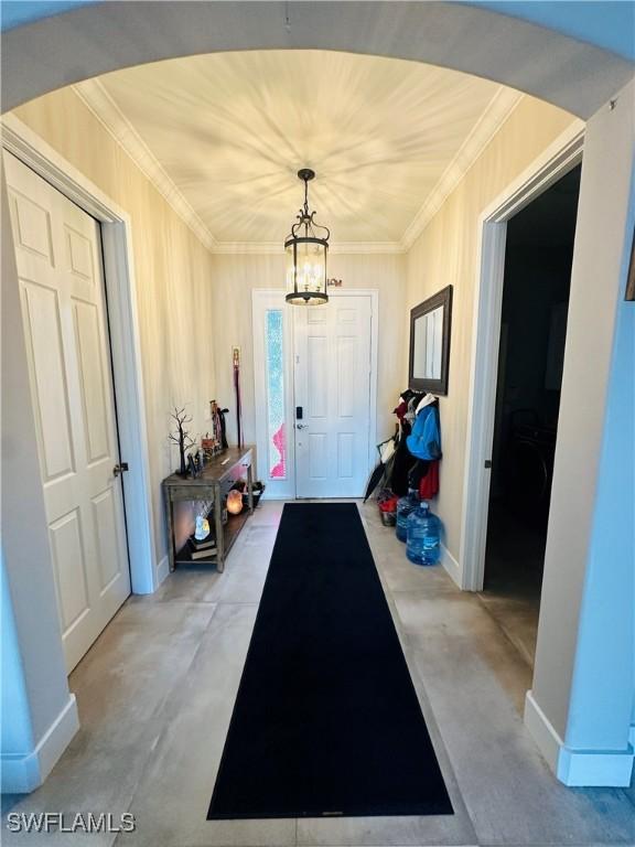 doorway featuring ornamental molding and an inviting chandelier