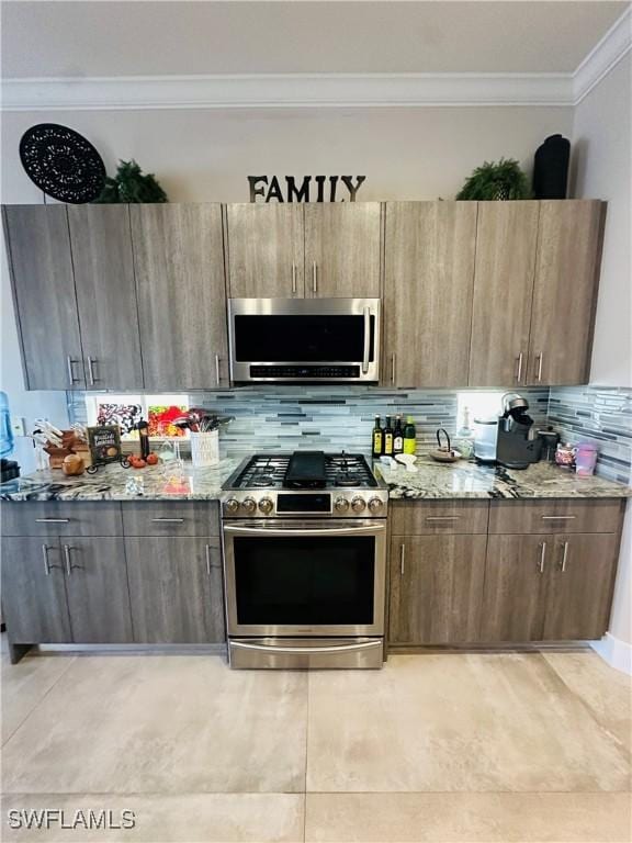 kitchen featuring appliances with stainless steel finishes, light stone counters, crown molding, and backsplash