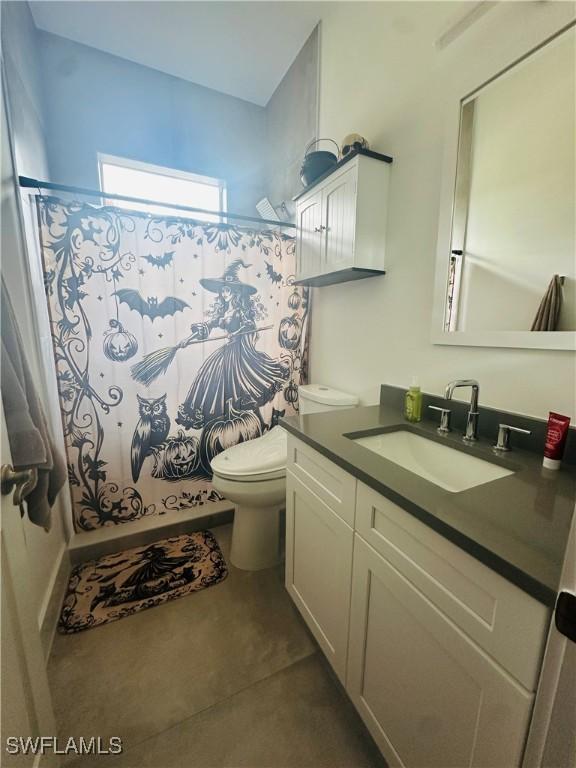 bathroom featuring vanity, toilet, and curtained shower