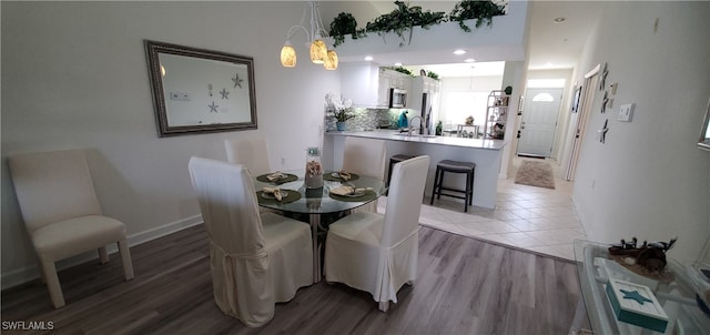 dining space featuring light wood-type flooring and sink