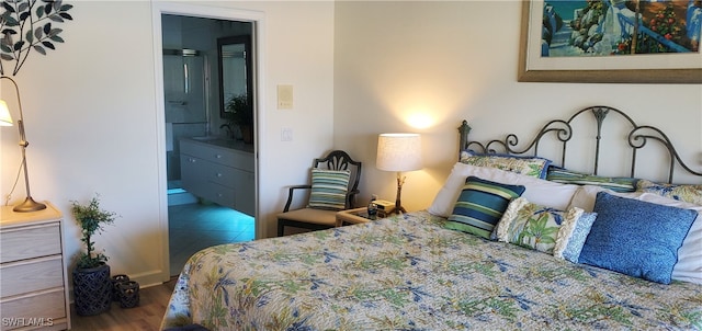 bedroom featuring dark wood-type flooring and ensuite bathroom