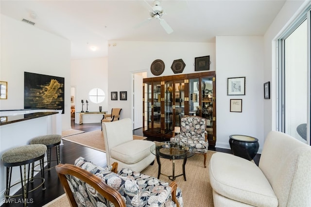 living area featuring lofted ceiling, visible vents, wood finished floors, and a ceiling fan