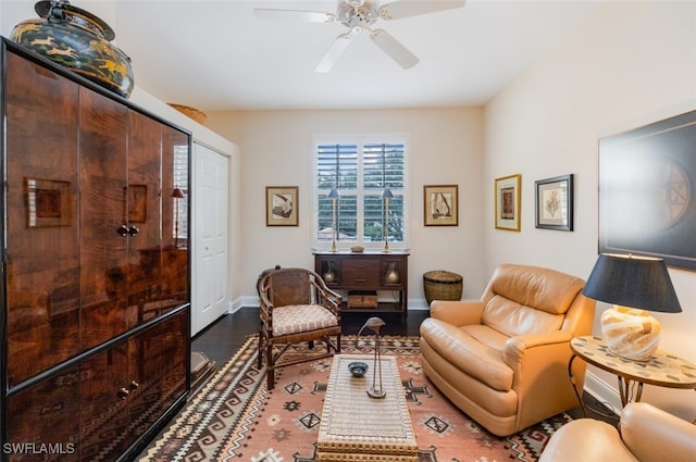 living area with ceiling fan, baseboards, and wood finished floors