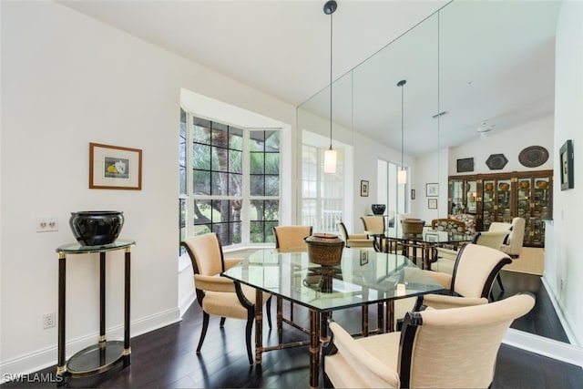 dining room with lofted ceiling, baseboards, and dark wood finished floors