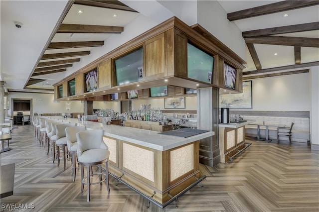 kitchen with vaulted ceiling with beams and glass insert cabinets