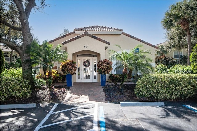 mediterranean / spanish home with uncovered parking, a tiled roof, and stucco siding