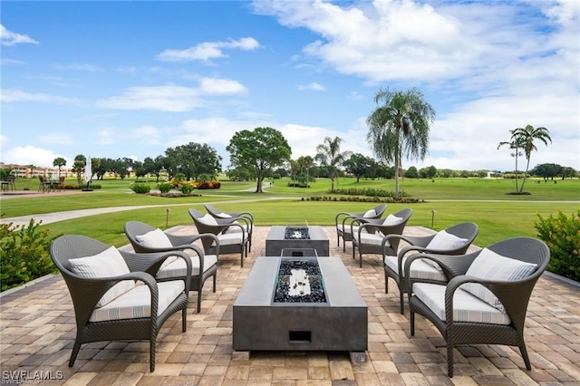 view of patio / terrace with view of golf course and an outdoor living space with a fire pit