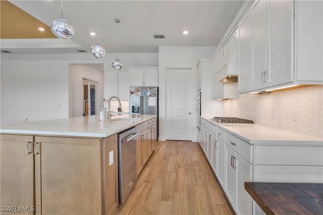 kitchen featuring stainless steel appliances, a large island, pendant lighting, light wood-type flooring, and white cabinets