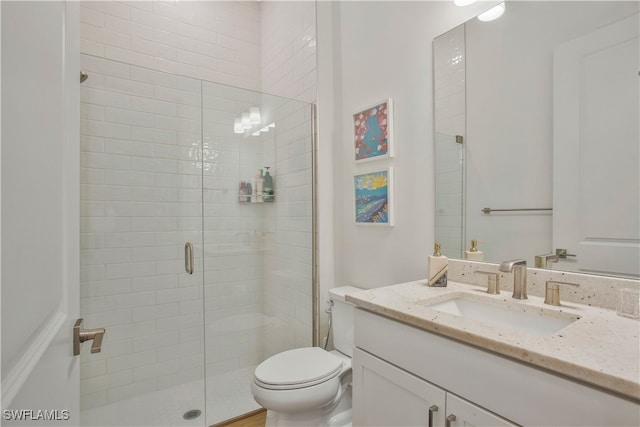 bathroom with vanity, toilet, and a shower with door