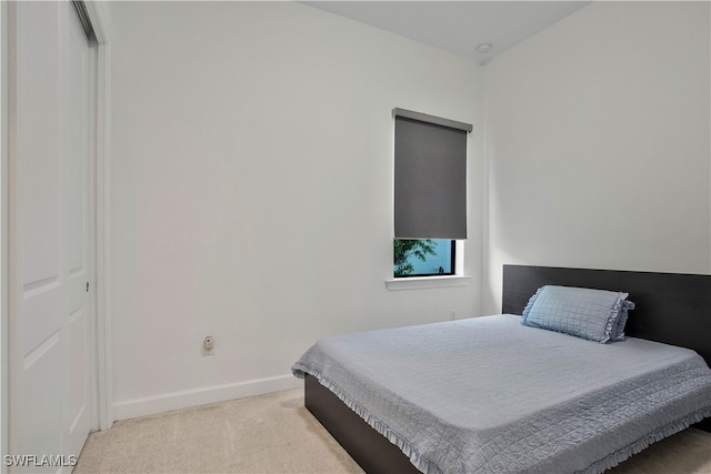 bedroom featuring a closet and light colored carpet