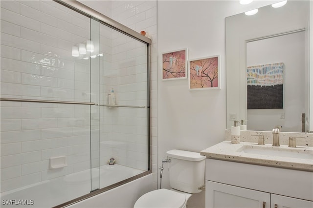 full bathroom with vanity, enclosed tub / shower combo, and toilet