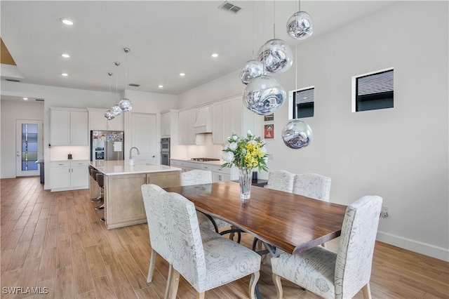 dining room featuring sink and light wood-type flooring