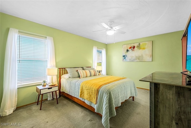 carpeted bedroom with ceiling fan and multiple windows