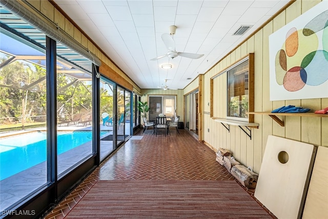 unfurnished sunroom with ceiling fan and a wealth of natural light