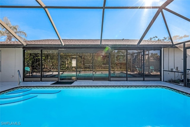 view of pool with a patio and a lanai