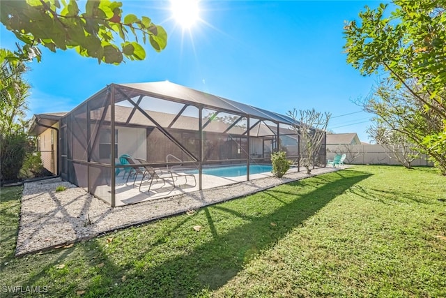 view of pool with glass enclosure, a yard, and a patio