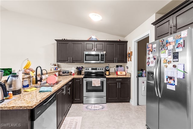 kitchen with lofted ceiling, light stone counters, appliances with stainless steel finishes, light tile patterned flooring, and sink