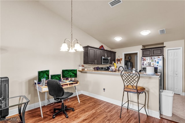 home office featuring vaulted ceiling, light hardwood / wood-style flooring, and a notable chandelier