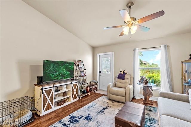 living room with ceiling fan, vaulted ceiling, and hardwood / wood-style floors