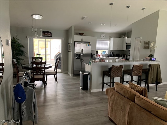 kitchen featuring pendant lighting, a wealth of natural light, stainless steel appliances, and white cabinets