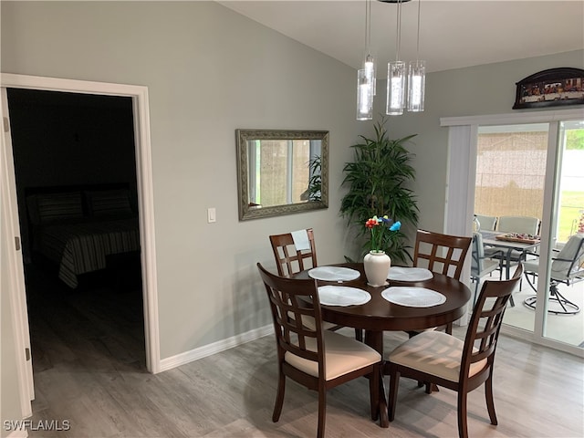 dining room featuring lofted ceiling and light hardwood / wood-style floors