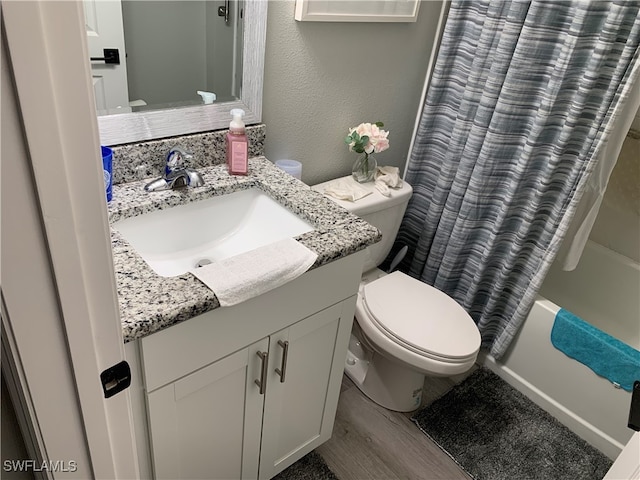 full bathroom featuring vanity, hardwood / wood-style floors, toilet, and shower / bath combo