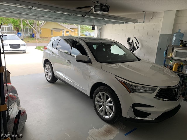 garage with electric panel, a garage door opener, and a carport