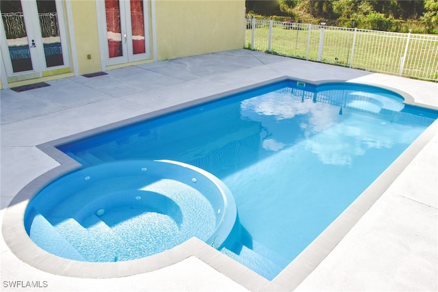 view of pool with french doors, an in ground hot tub, and a patio area