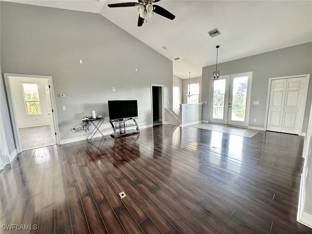 living room with dark wood-type flooring, high vaulted ceiling, and a wealth of natural light