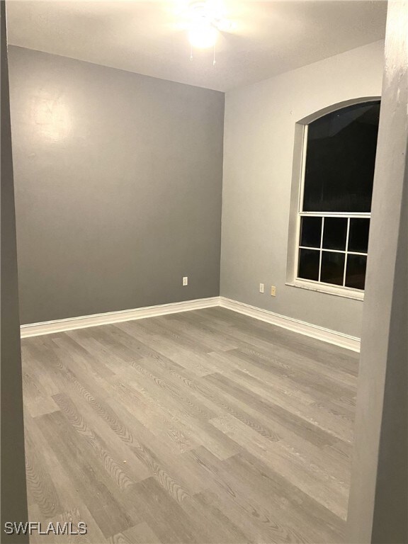 spare room with hardwood / wood-style flooring and ceiling fan