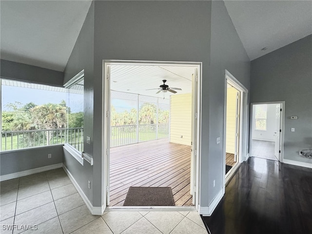 doorway to outside with ceiling fan, light tile patterned floors, and high vaulted ceiling