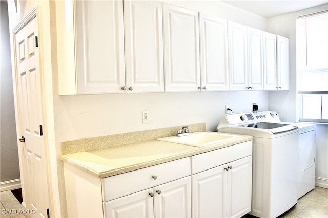 laundry room with light tile patterned floors, cabinets, sink, and independent washer and dryer