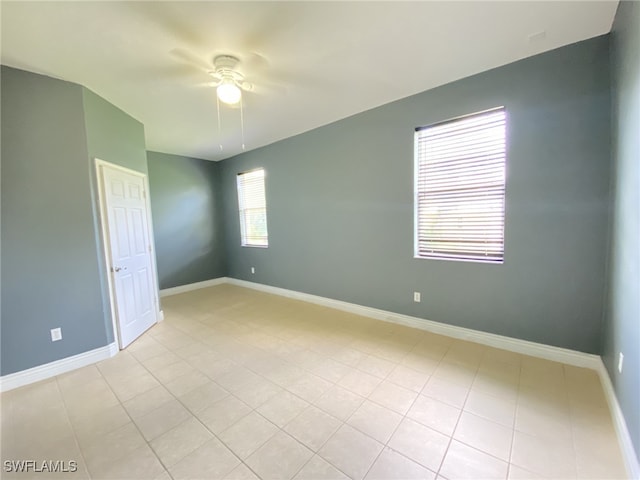 tiled empty room featuring ceiling fan