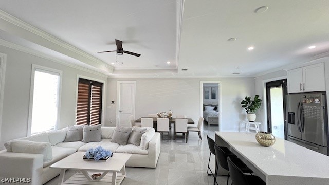 living room with crown molding and ceiling fan