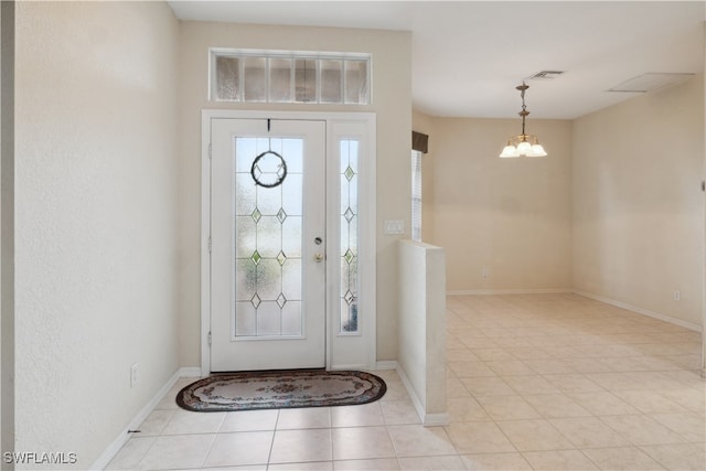 foyer featuring a notable chandelier and light tile patterned flooring