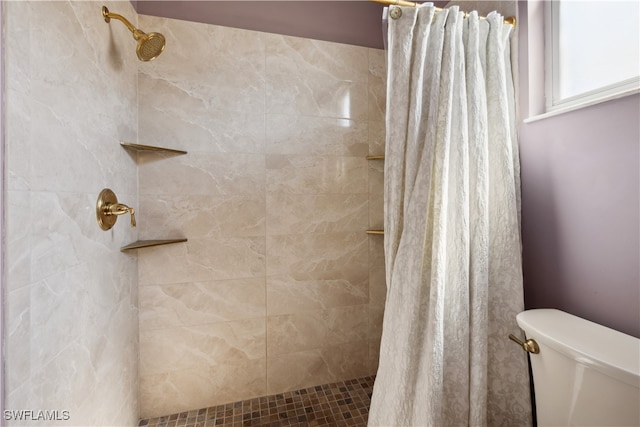 bathroom featuring curtained shower and toilet