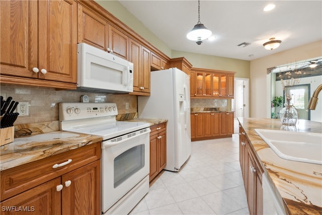 kitchen with sink, tasteful backsplash, wood counters, pendant lighting, and white appliances