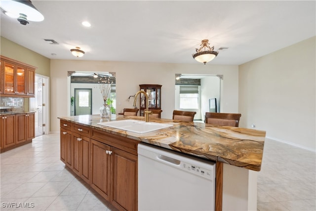 kitchen featuring a center island with sink, sink, white dishwasher, and plenty of natural light