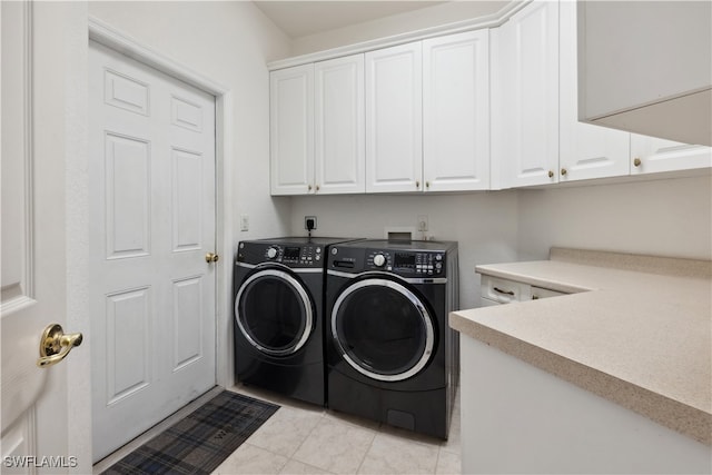 washroom featuring cabinets, independent washer and dryer, and light tile patterned floors